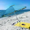 A blue beach umbrella is set up on a sandy beach next to the ocean. Anteprima dell’immagine prodotto