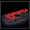 A red and black toy crane truck is displayed against a black background. Voir les images du produit