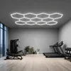 A modern home gym with exercise equipment and a hexagonal ceiling light. Voir les images du produit