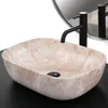 A beige oval countertop sink with a black faucet and drain. Anteprima dell’immagine prodotto
