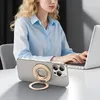 A woman is working on a laptop with a phone with a ring holder in the foreground. Podgląd zdjęcia produktu