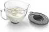 A glass mixing bowl filled with whipped cream and a gray lid next to it. Voir les images du produit