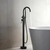 A black freestanding bathtub faucet with water running into a white bathtub. Produktbild-Vorschau