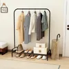 A clothing rack with clothes, shoes, and boxes displayed in a room. Produktbild-Vorschau