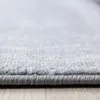 A close-up, low-angle shot of the edge of a gray carpet on a wooden floor. Voir les images du produit