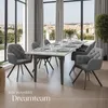 A dining room with a table and chairs set for a meal, with a city view through large windows. Náhled obrázku produktu