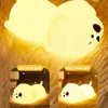 A cute, glowing puppy-shaped LED night light is shown in various brightness settings. Produktbild-Vorschau