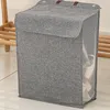 A grey laundry basket with a lid and mesh sides is shown standing on a tiled floor. Produktbild-Vorschau
