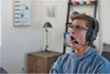 A young person wearing headphones and a hoodie, looking off to the side with their mouth open. Anteprima dell’immagine prodotto