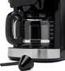 Close-up of a black coffee maker with a glass carafe and a silver base. A black scoop is in the foreground. Anteprima dell’immagine prodotto