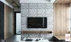 A modern living room with a TV mounted on a textured geometric wall, a wooden shelf, and a wooden bench. Produktbild-Vorschau