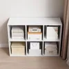 A white cube shelf unit filled with books and storage boxes. Produktbild-Vorschau