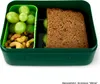 A green lunchbox containing grapes, nuts, and a sandwich. Podgląd zdjęcia produktu