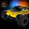 A close-up, angled view of a yellow and black remote-controlled monster truck with large wheels and blue suspension springs, set against a gradient background of blue and orange. Voir les images du produit
