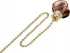 A close-up studio shot of a gold beaded pull chain with a clear and gold switch mechanism against a white background. Podgląd zdjęcia produktu