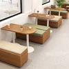 A modern cafe interior with wooden tables and benches with green and beige cushions. Produktbild-Vorschau