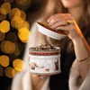A person is holding a Christmas-themed cookie jar filled with cookies. Anteprima dell’immagine prodotto
