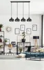 A modern living room with a black pendant light fixture, a sofa, a chair, and shelves with decorative items. Podgląd zdjęcia produktu