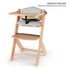 A wooden high chair with grey cushions and a tray, shown from a 3/4 angle. Produktbild-Vorschau