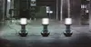 Three portable LED work lights are set up in a dark, industrial-looking space, possibly a warehouse or parking garage. Anteprima dell’immagine prodotto
