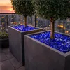 Blaue Glasbrocken als dekorative Abdeckung in großen Pflanzkübeln auf einer Terrasse Produktbild-Vorschau