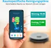A hand holds a smartphone displaying a robot vacuum app interface, with a robot vacuum cleaner visible in the background. Produktbild-Vorschau