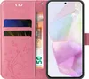 A pink flip phone case with floral and butterfly designs, showing card slots and a banknote. Produktbild-Vorschau