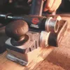 A close-up shot of a Bosch electric hand planer being used on a wooden surface. Voir les images du produit