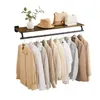 A wall-mounted shelf with a hanging rod, displaying several shirts and accessories. Produktbild-Vorschau