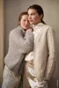 Two women posing together, wearing knitted sweaters and pants. Produktbild-Vorschau