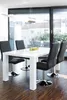 A dining table with chairs in a modern room with large windows. Produktbild-Vorschau