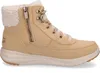 A side view of a beige Skechers boot with a cream-colored sherpa lining. Voir les images du produit