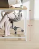 A person is sitting at a desk with a laptop and a small plant on it. A measurement indicator shows the height of the desk. Produktbild-Vorschau