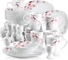 A collection of white ceramic dinnerware with a pink cherry blossom pattern, arranged in a studio setting. Voir les images du produit