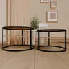 Two round metal table frames with wooden shelves are placed on a wooden floor in a room with a slatted wooden partition and a potted plant. Voir les images du produit