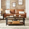 A living room scene featuring a brown leather couch, a coffee table, and decorative items. Produktbild-Vorschau