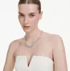 A woman wearing a white strapless dress and a diamond necklace. Produktbild-Vorschau