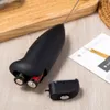 A black electric milk frother with batteries inserted is placed on a wooden surface next to a small card. A part of the frother's battery cover is detached. Produktbild-Vorschau