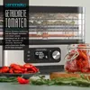 A food dehydrator is shown with dried tomatoes and ingredients for preserving them. Produktbild-Vorschau