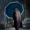 A woman holding a blue umbrella in the rain at night. Náhled obrázku produktu