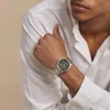 A man wearing a white shirt and a silver watch. Produktbild-Vorschau