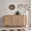 A wooden sideboard with rattan detailing is displayed against a neutral wall, adorned with a decorative wall plate and a vase with branches. Anteprima dell’immagine prodotto