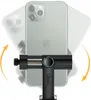 A smartphone is mounted on a black adapter/tripod holder, with arrows indicating rotation. Produktbild-Vorschau