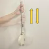 Hands holding a retractable clothesline attached to a wall. Voir les images du produit