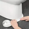 Hands applying a white sealing tape to the base of a white toilet. Anteprima dell’immagine prodotto