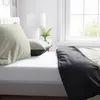 A neatly made bed with pillows and a blanket. Produktbild-Vorschau