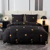 A bed with black bedding featuring a gold floral pattern. Produktbild-Vorschau