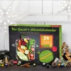 A festive scene with a product box, Christmas decorations, and pine cones. Produktbild-Vorschau
