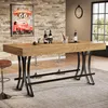 A bar table with bottles of wine and glasses on it, set in a dining room with a brick wall and a large window. Voir les images du produit