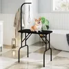A dog grooming table is set up in a bathroom with a bathtub and a bathrobe hanging on a rack. Anteprima dell’immagine prodotto